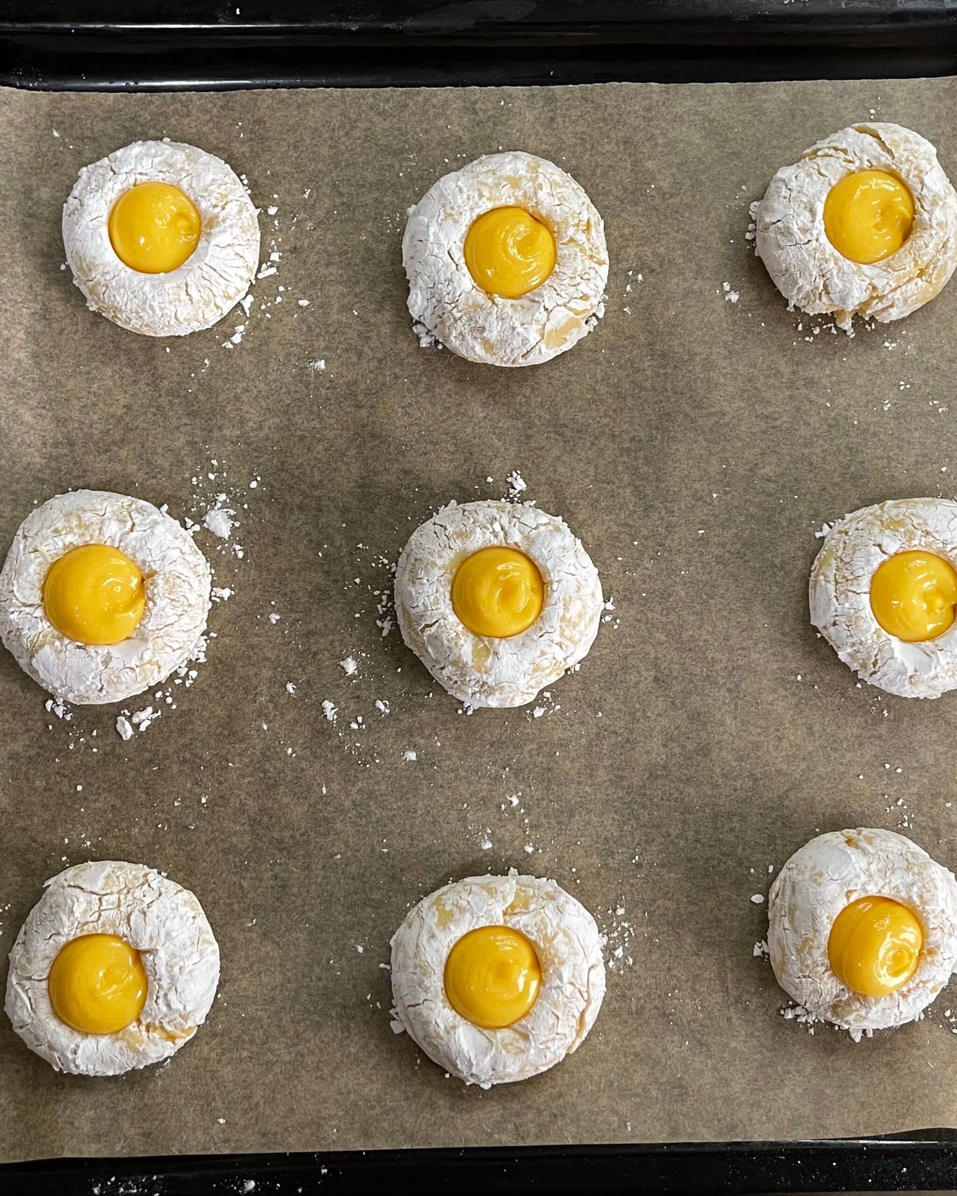 I biscotti sono ricoperti di zucchero a velo e hanno un centro giallo.