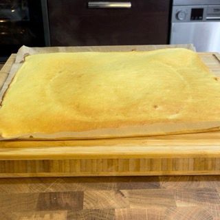 Un pezzo di torta è appoggiato su un tagliere di legno