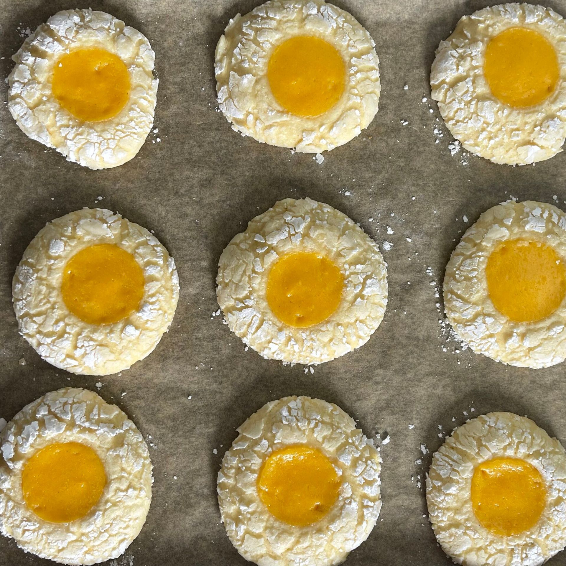 Un mucchio di biscotti con un centro giallo su una teglia da forno