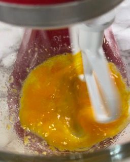 Un mixer sta mescolando un liquido giallo in una ciotola di vetro.