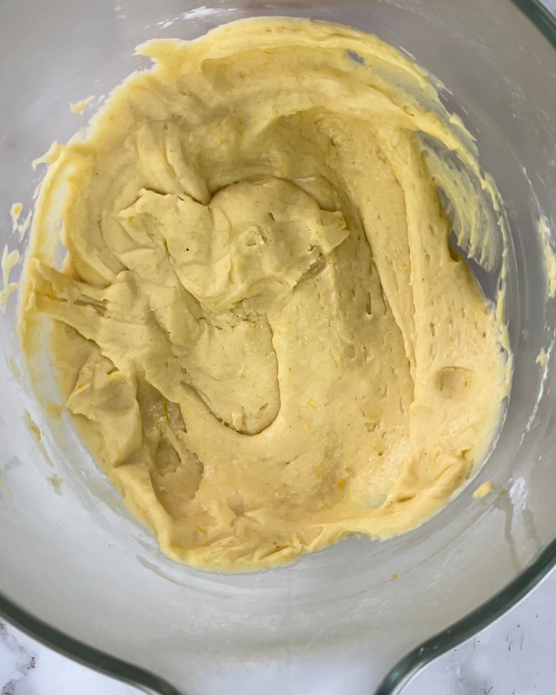 Primo piano di una ciotola di pastella gialla su un tavolo.