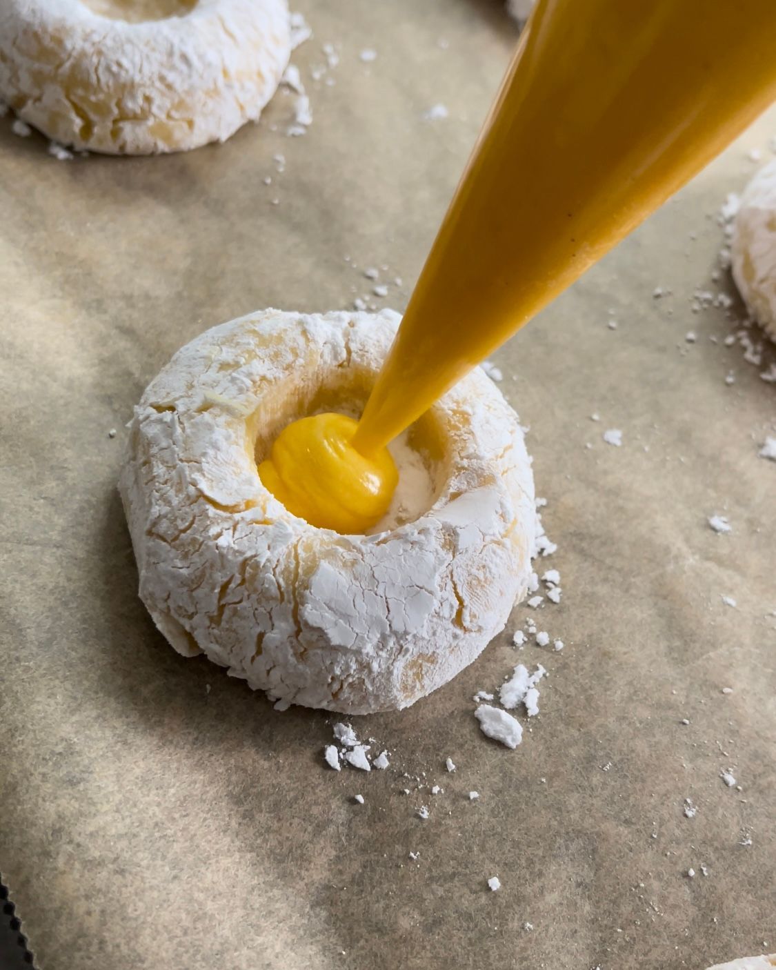 Una persona sta versando un liquido giallo in un biscotto.