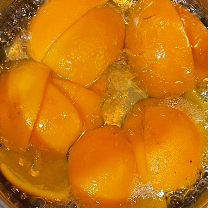 Un primo piano di arance tagliate a fette in una pentola d'acqua