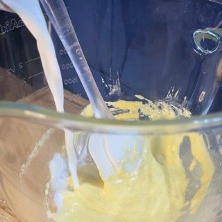 Una persona sta versando il latte in una ciotola di liquido giallo