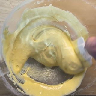 Una persona sta mescolando un liquido giallo in una ciotola