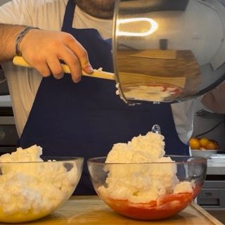 Un uomo con un grembiule blu sta versando qualcosa in una ciotola