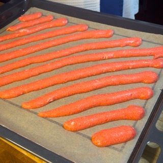 Un mazzo di carote è adagiato su una teglia da forno