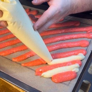 Una persona sta versando la glassa su una teglia di biscotti