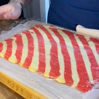 Un pezzo di cibo a strisce rosse e bianche è avvolto in pellicola di plastica