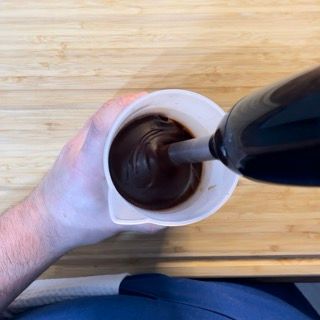 Una persona versa del liquido in un misurino.