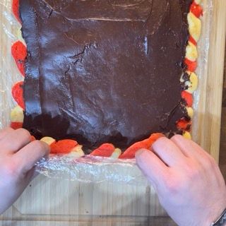 Una persona tiene in mano un pezzo di torta al cioccolato