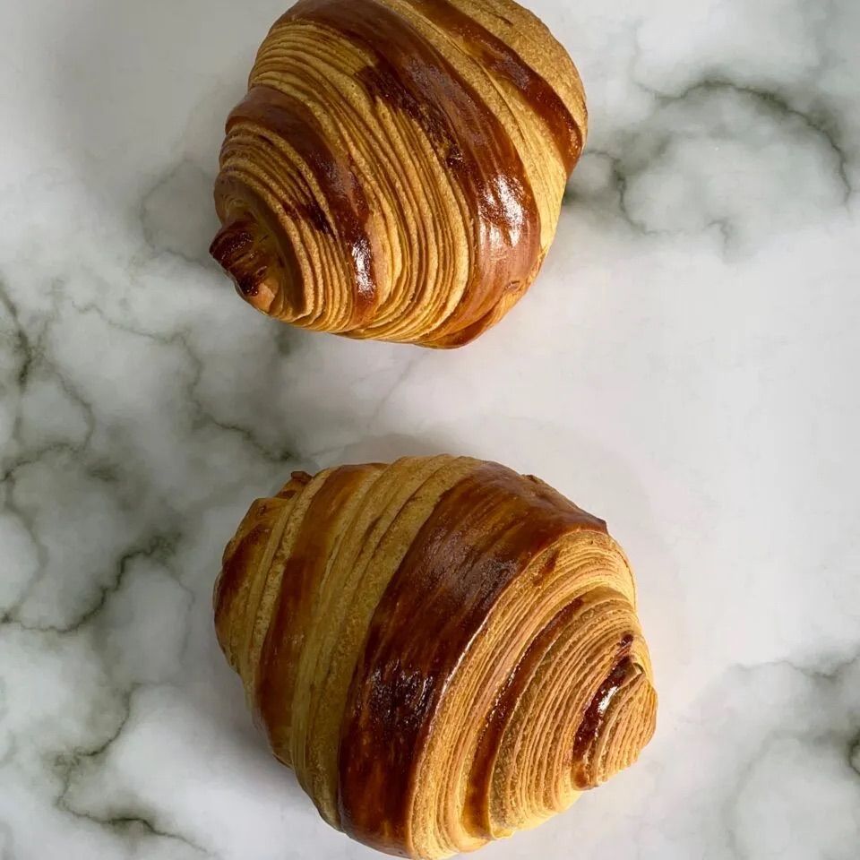 Croissant francesi appena sfornati, dorati e sfogliati, pronti per una colazione deliziosa.