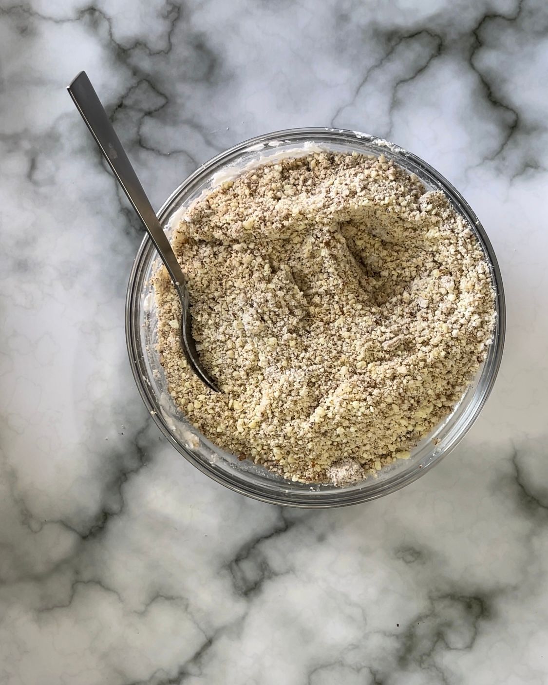 Una ciotola di cibo con un cucchiaio dentro su un tavolo.