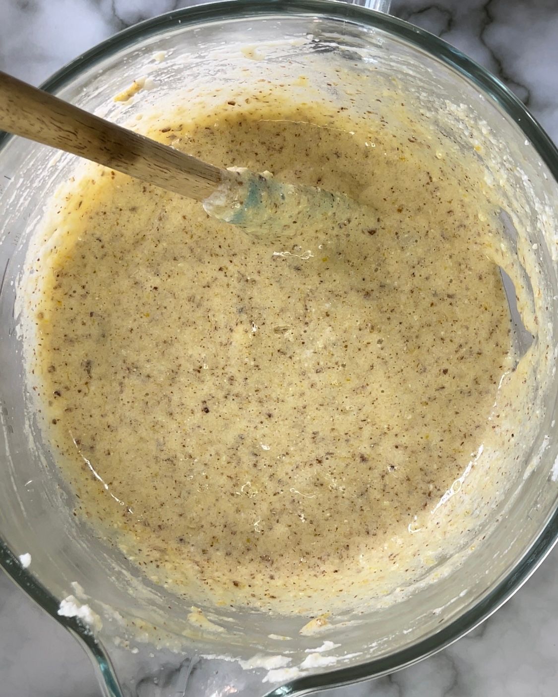 Una ciotola di pastella con un cucchiaio di legno dentro.