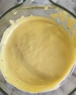 Primo piano di una ciotola di salsa gialla su un tavolo.