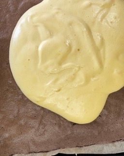 Un primo piano di una sostanza gialla su una superficie marrone.