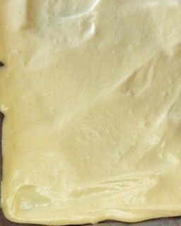 Primo piano di un pezzo di salsa gialla su un tavolo.