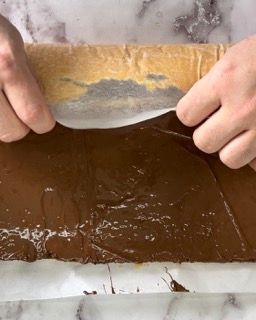 Una persona sta tagliando un pezzo di torta al cioccolato con una spatola.