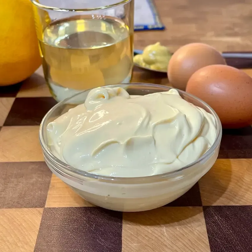 Ciotola di maionese fatta in casa densa e cremosa, pronta da servire.