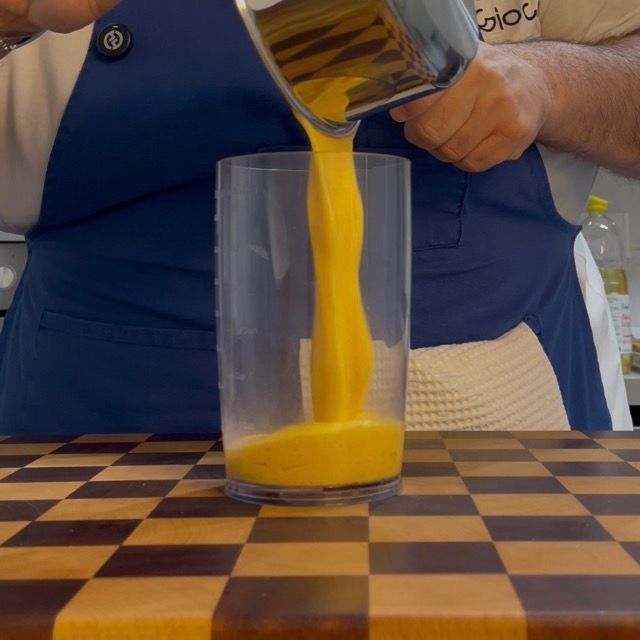 Base di uova pastorizzate trasferita in un contenitore alto e stretto.