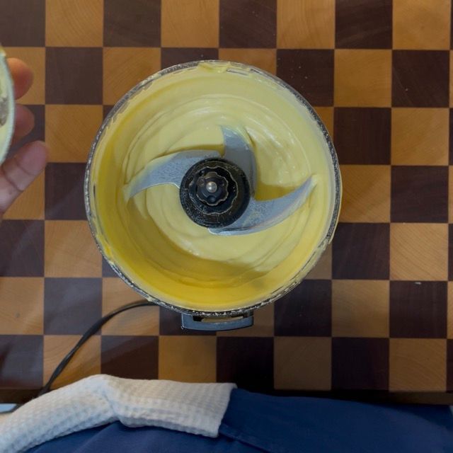 Frullatore a immersione in azione che emulsiona l'olio con le uova sode.