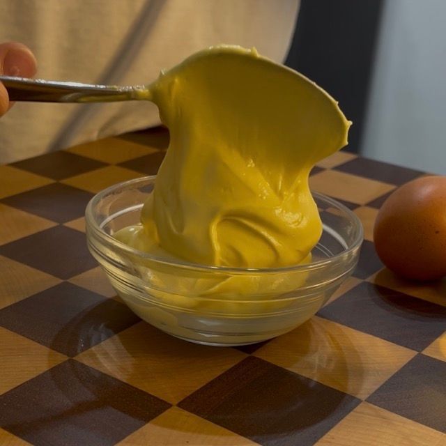 Maionese con uova sode pronta nel contenitore, liscia e senza grumi.
