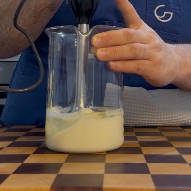 Inizio dell'emulsione: la maionese vegana inizia a montare e diventare bianca sul fondo.