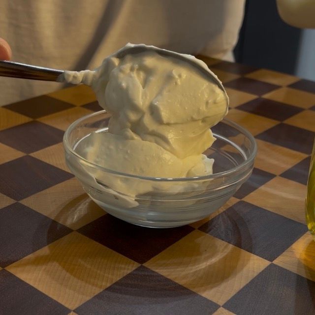 Dettaglio della cremosità della maionese vegana sul cucchiaio.