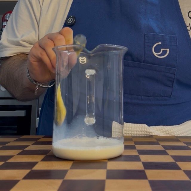 Latte di soia non zuccherato versato nel contenitore alto insieme a sale e aceto