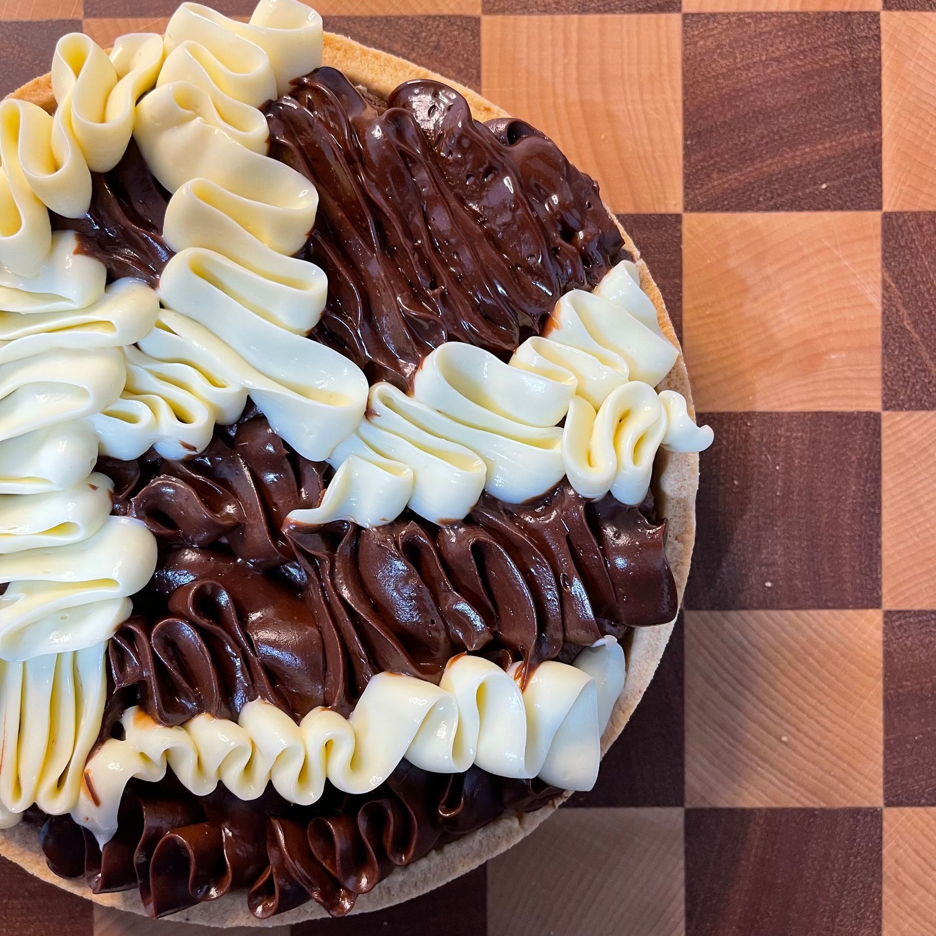 Crostata brownie intera appena sfornata, con la sua tipica superficie crepata da brownie e un bordo