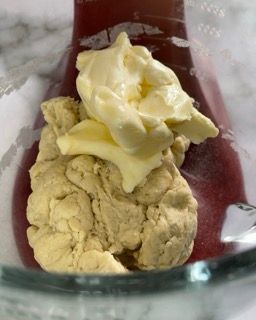 Una ciotola di pasta con sopra del burro.