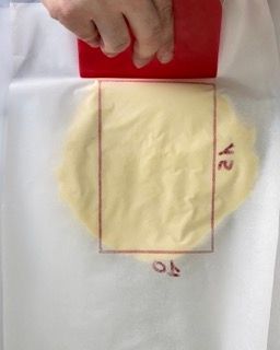 I lembi della carta da forno ripiegati per sigillare il panetto di burro.