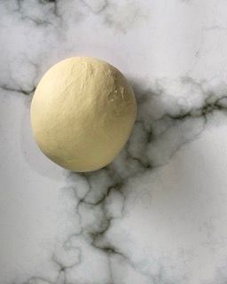 Impasto steso in una forma rettangolare su un vassoio.