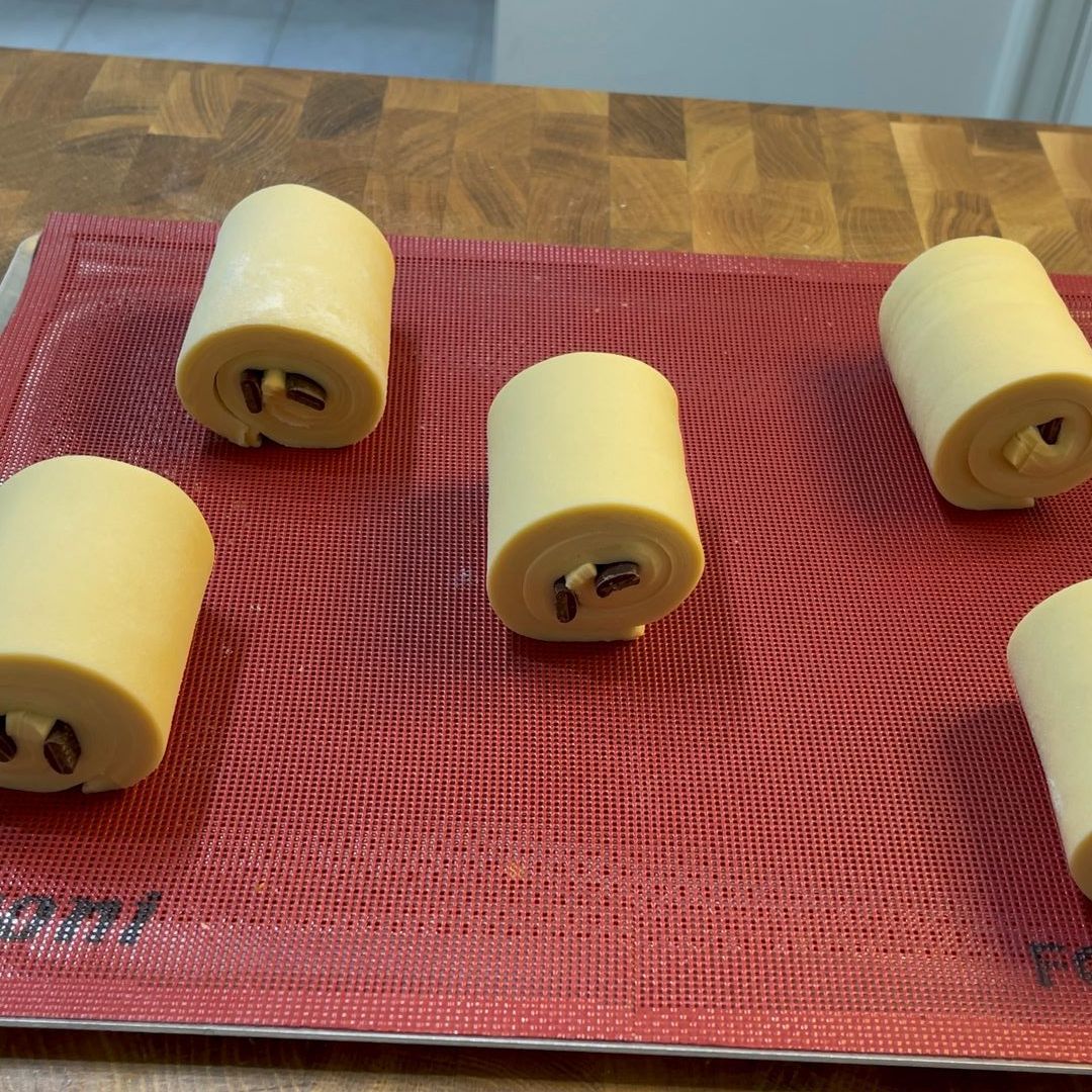 Pain au chocolat crudi disposti su una teglia, ben distanziati.