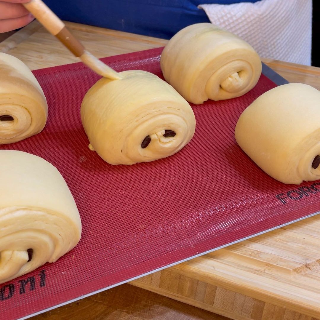 Superficie dei pain au chocolat spennellata con tuorlo e panna.