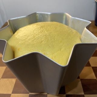 Una torta gialla in una teglia a forma di stella su un tavolo a scacchi