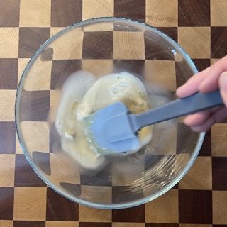 Una persona sta mescolando qualcosa in una ciotola con una spatola