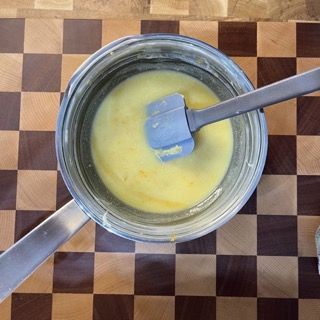 Una pentola di liquido giallo con una spatola dentro