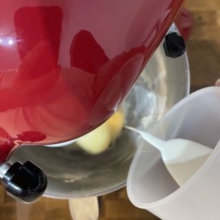 Una ciotola rossa viene versata in una tazza bianca.