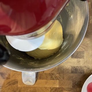 Primo piano di un'impastatrice con una palla di impasto al suo interno.