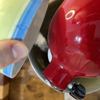 Una persona sta versando la farina in un mixer rosso