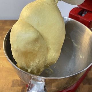 Un grosso pezzo di impasto viene versato in una ciotola di metallo