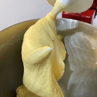 Un cucchiaio spunta da una ciotola di impasto.