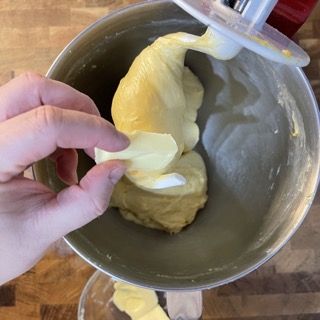 Una persona sta prendendo un pezzo di impasto da un'impastatrice