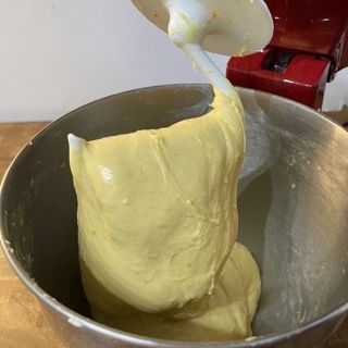 Un mixer sta mescolando una sostanza gialla in una ciotola di metallo