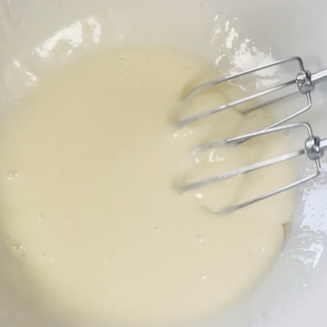 Primo piano di un mixer in una ciotola piena di liquido.