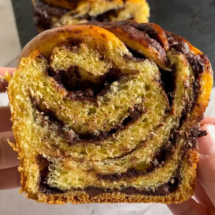 Babka al cioccolato intrecciato appena sfornato con ripieno fondente a vista