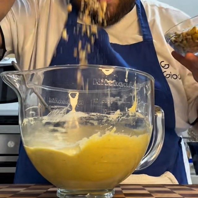 Spatola che incorpora delicatamente le gocce di cioccolato e le noci nell'impasto.