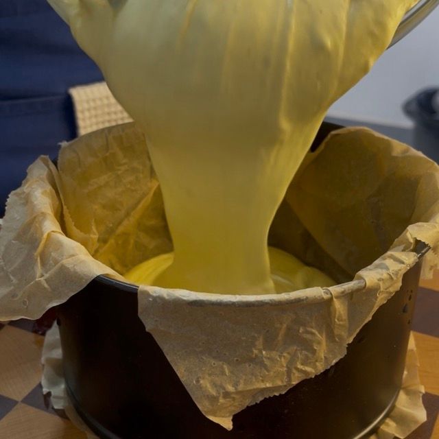 Pastella della cheesecake versata nella teglia foderata