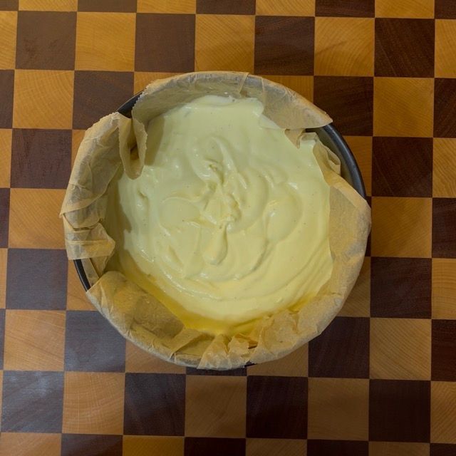 Pastella della cheesecake nella teglia foderata